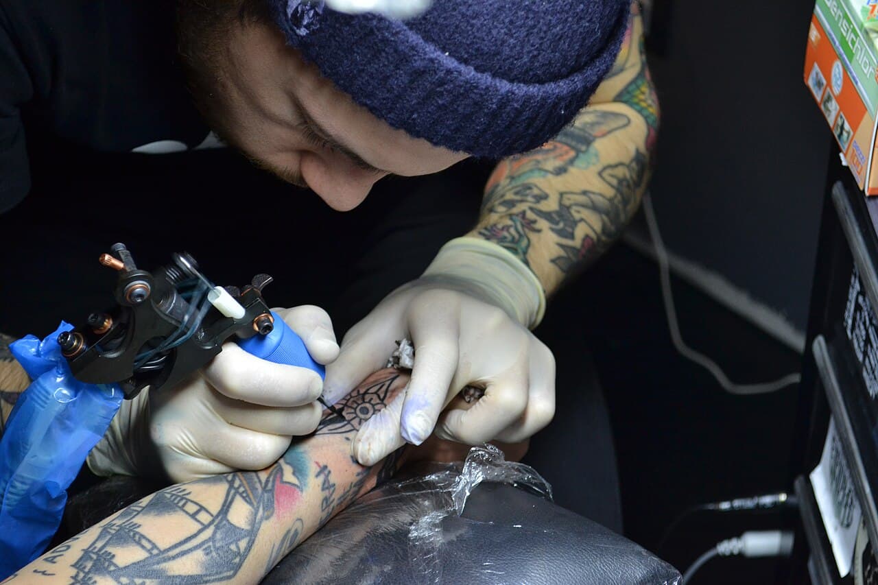 Tatuador tatuando en Bendito Veneno